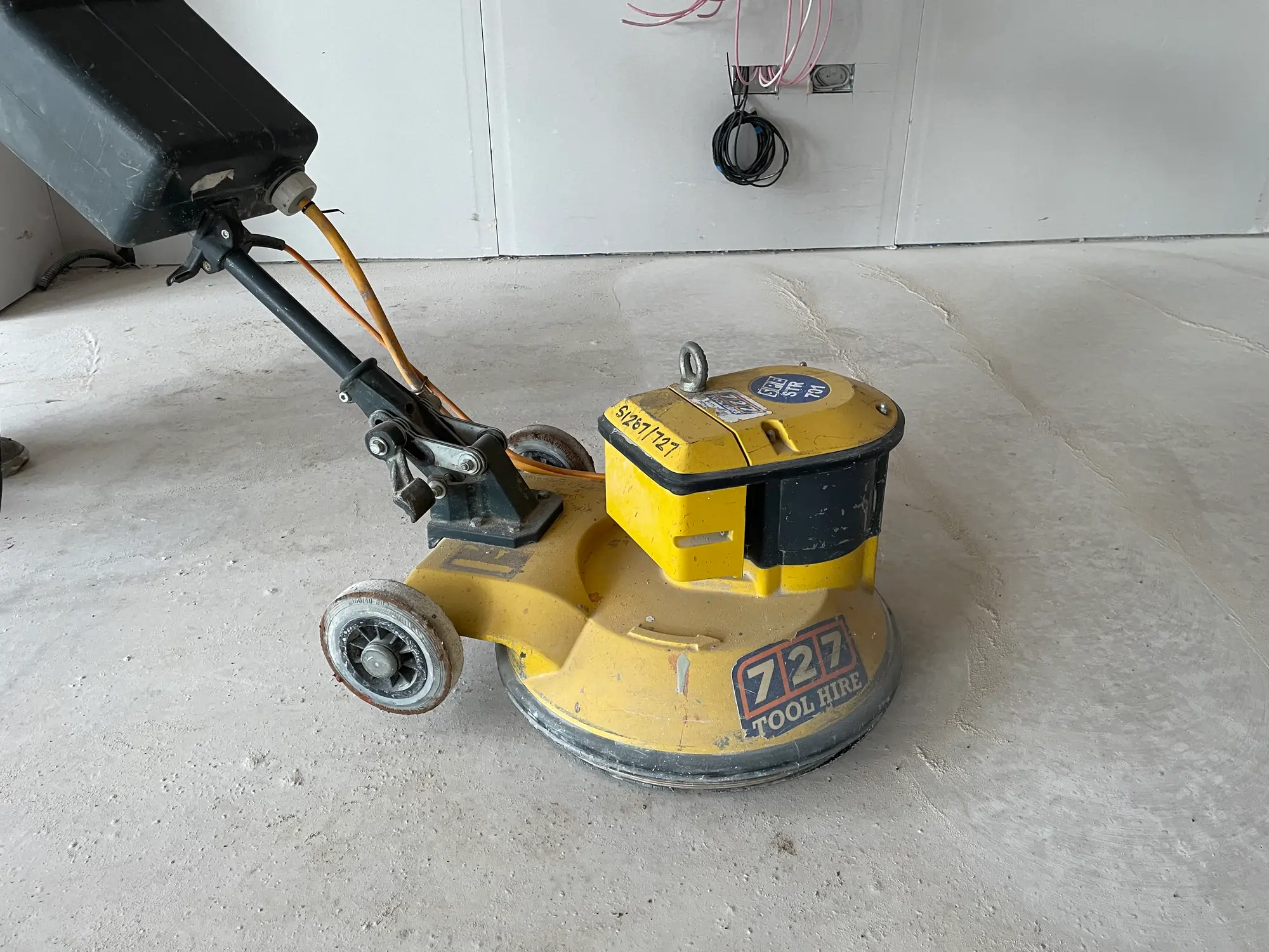 Photo of a yellow sanding machine for floors
